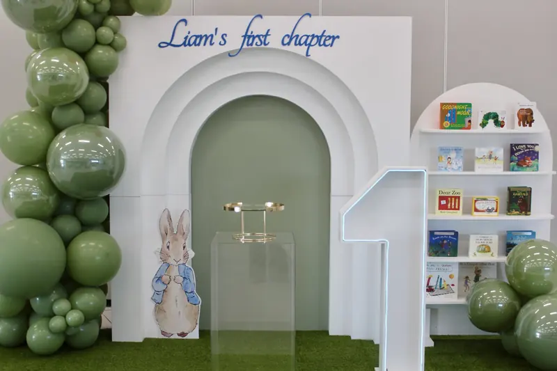Liam's First Chapter: A storybook first birthday with a sage garland, triple arch and a shelf of favourite books.