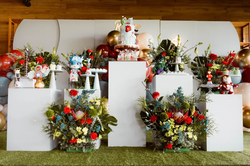 Ryan: Bold red, blue and gold with native florals and hero figurines on white plinths.