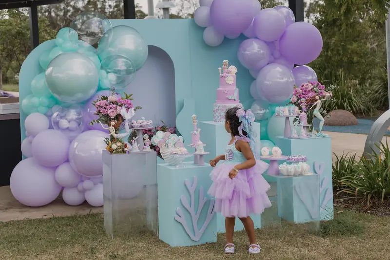 Sarah 5 Years: Lilac and aqua balloons, coral cut-outs and mermaid details, styled outdoors.